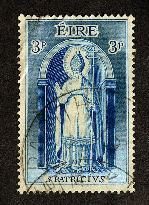 A vintage stamp showing St Patrick with snakes beneath his feet. Photo: iStock