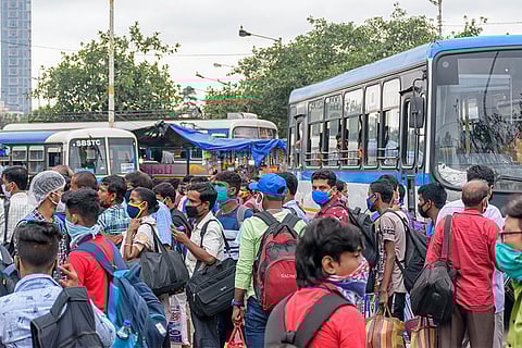 कोरोना के दौरान बस स्टैंड पर प्रवासियों का लगा तांता; फोटो: आईस्टॉक