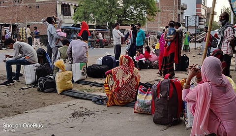 पलायन की तैयारी: हमीरपुर जिले के राठ कस्बे में प्राइवेट बस का इंतजार करते मजदूर। फोटो: अमन गुप्ता