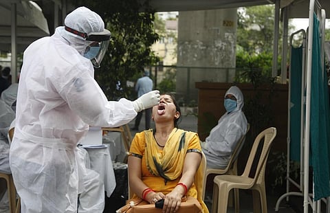 A health worker collects a swab sample for RT-PCR Covid-19 test of a woman at a sample collection centre during the nationwide lockdown in New Delhi in 2020. IStock photo