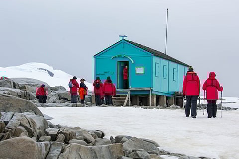 Tourists at the historic Damoy Hut, a scientific research station on the west side of Wiencke Island. The area is known as Damoy Point.