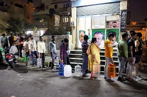 Residents of a neighbourhood in Bengaluru line up for receiving water in March 2024