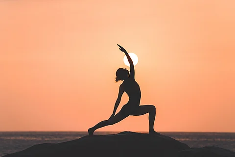 Silhouette of a woman doing yoga during sunset