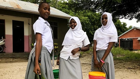 Students at Kingani Secondary School carrying buckets of water