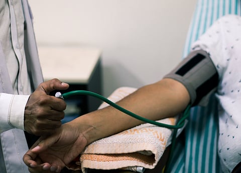 Midsection Of Doctor Examining Blood Pressure Of Patient In Hospital stock photo