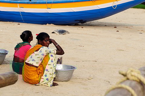 Indian fishermen are waiting on the beach for the boats returning from the fishing