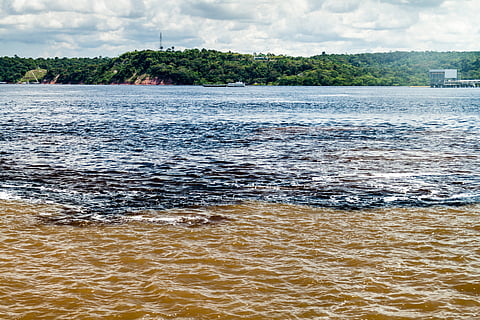 The confluence between the Rio Negro river with dark water and the lighter river or Rio Solimoes.