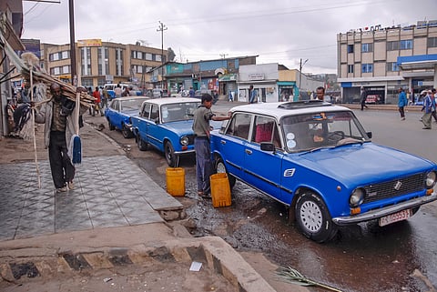 boy washes a taxi car on a street of Addis Ababa, Ethiopia. Ethiopian children often have to work instead of studying at school.