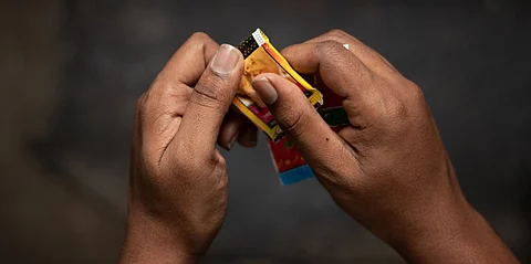 Close up of a man hand tearing a packet of chewing tobacco or Gutka