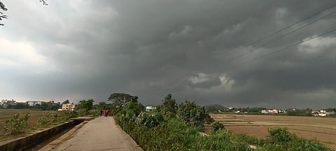 A village in Kendrapara district stands beneath darkening skies, as black clouds gather on the horizon with Cyclone Dana drawing near.