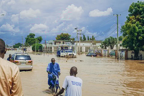 People commuting through flood waters in Maiduguri, north-east Nigeria, 2024.