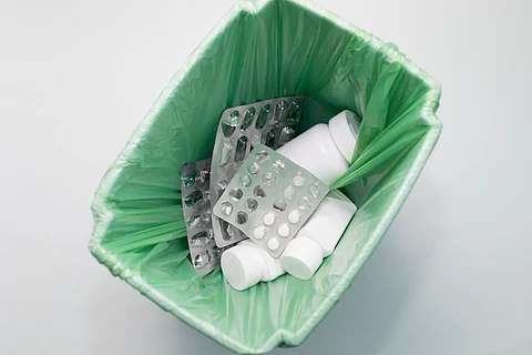 Top View: Medication, Supplement, Pills, Tablet Bottles, and Empty Capsule Pastilles in Trash Bin