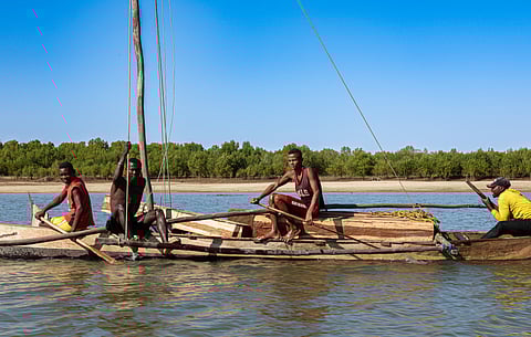 Fishermen work together on a wooden vessel in Morondava, Madagascar.
