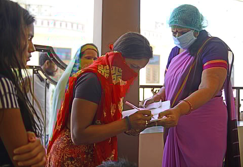 Anganwadi workers distributing wheat during the COVID-19 pandemic.
