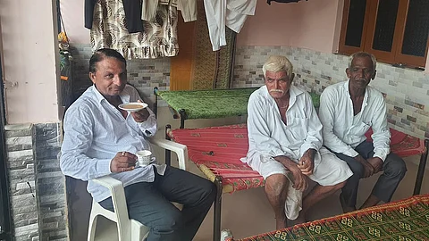 Family members and Deputy Sarpanch Ranavasia Babubhai Kalubhai sit at the Sarpanch's house in Ukarda.