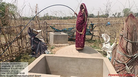 In Pipra village, a beneficiary woman repairs the pipe of the biogas plant installed in her home.