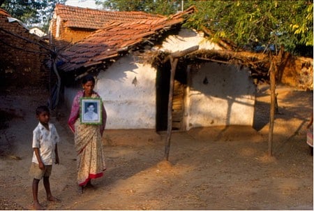 A family member holding a picture of a cotton farmer who committed suicide due to farm loss and bank loan in Warangal district of Andhra Pradesh, India. Photo from 1998.
