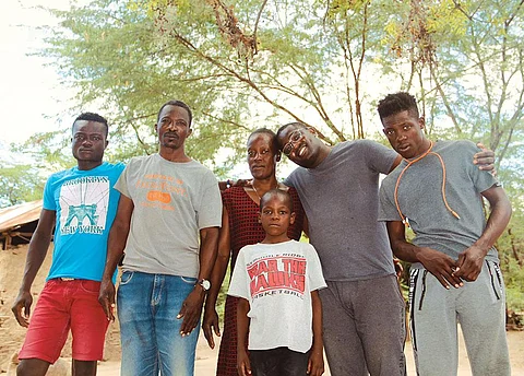 Raynold Louima (second from left) had to flee Haiti due to the impact of recurring natural disasters on his life and livelihood. Today, he lives in Brazil and is trying to get his family out of Haiti