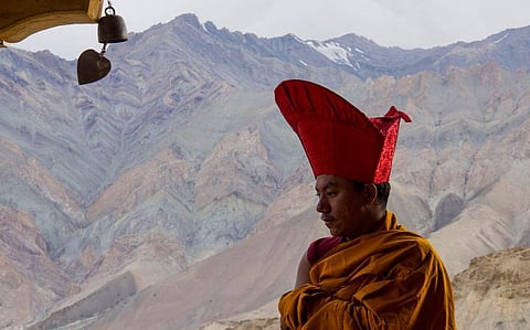 A small patch of snow on the mountain can be seen behind the bhikkhu (monk), which otherwise used to be fully covered with snow. Photo: Tonyot K Yuru