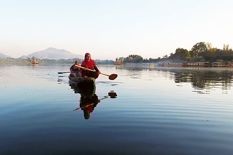 मवेशियों को खिलाने के लिए डल झील से कमल के पत्ते इकट्ठा कर घर लौटती महिलाएं; फोटो: आईस्टॉक
