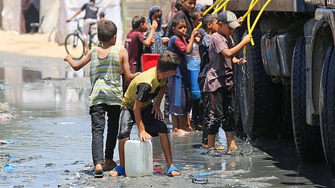 गाजा में साफ पानी के लिए संघर्ष करते बच्चे और लोग; फोटो: संयुक्त राष्ट्र एजेंसी यूएएनआरडब्ल्यूए