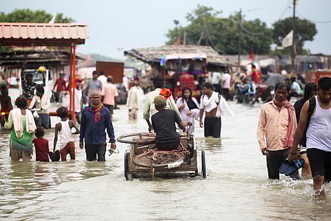 प्रयागराज में आई बाढ़ के चलते सुरक्षित स्थानों पर पलायन करते लोग; फोटो: आईस्टॉक
