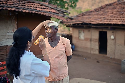 ग्रामीण भारत में एक बुजुर्ग के आंखों की जांच करती महिला डॉक्टर; फोटो: आईस्टॉक