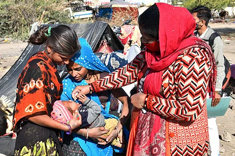एक फरवरी, 2021: राजस्थान के ब्यावर में पल्स पोलियो उन्मूलन कार्यक्रम के दौरान एक आंगनवाड़ी स्वास्थ्य कार्यकर्ता एक झुग्गी बस्ती में बच्चे को पोलियो की दवा पिलाती हुई