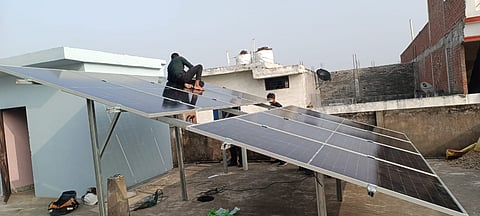 प्रयागराज के एक घर में सोलर पैनल लगाते हुए कर्मी। फोटो: विवेक आर्य