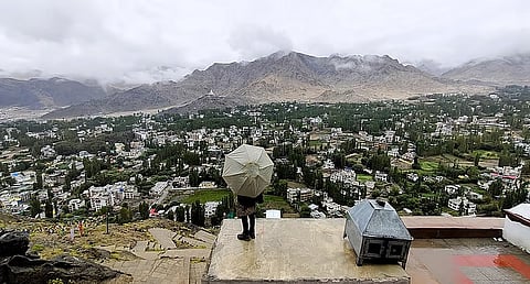 बारिश में लेह शहर के दृश्य का आनंद लेता एक पर्यटक।फोटो: लेखक द्वारा प्रदत्त