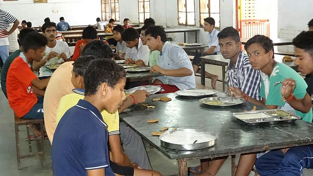 नवोदय विद्यालय में एक साथ बैठकर खाना खाते बच्चे