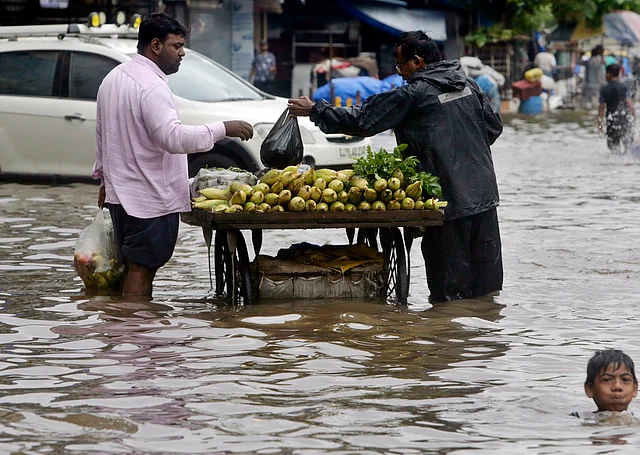 मुंबई में भारी बारिश के बावजूद भुट्टा बेचता विक्रेता