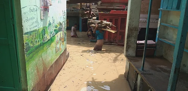 शव जलाने के लिए लकड़ी ढोते लोग