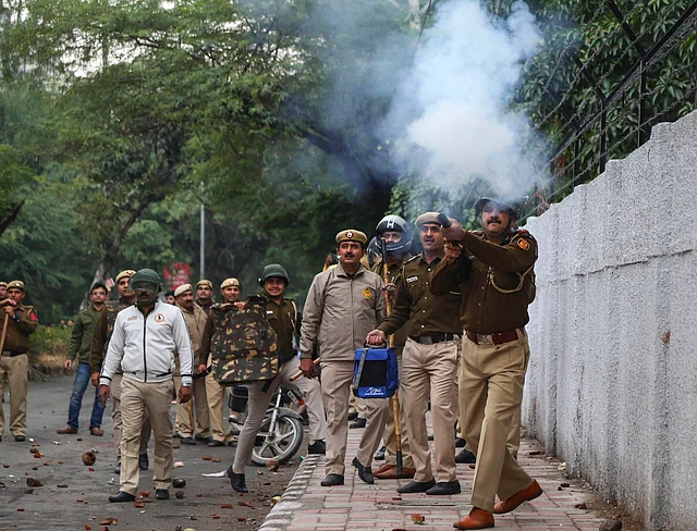 दिल्ली में प्रदर्शन करते लोगों को काबू करने के लिए आंसू गैस के गोले दागती पुलिस 