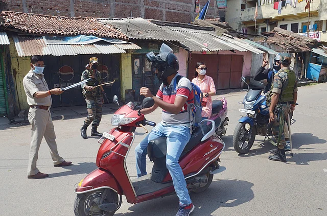 झारखंड के रांची में लोगों को बाहर निकलने से रोकते पुलिसवाले