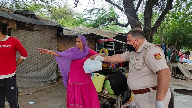 कालकाजी इलाके में खाने का सामान बांटते पुलिस अधिकारी