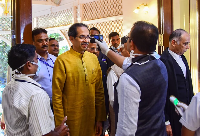 मुंबई में राजभवन में सीएम उद्धव ठाकरे की थर्मल स्क्रीनिंग करता कर्मचारी