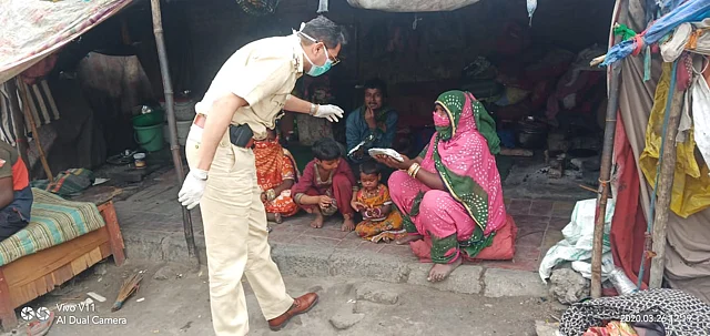 दिल्ली के राजौरी गार्डन इलाके में लोगों को जरूरत का सामान देते पुलिस अधिकारी