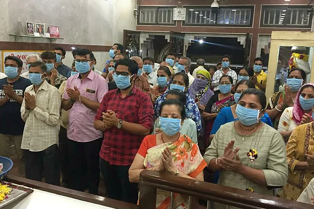 सूरत के एक मंदिर में मास्क लगाकर पूजा करते लोग