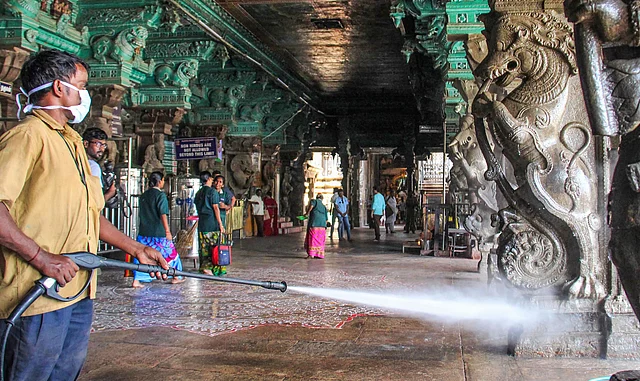 मदुरै में मीनाक्षी अम्मन मंदिर में डिसइंफेक्टेंट का छिड़काव करता स्वास्थ्य अधिकारी