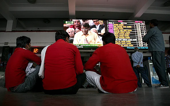 Porters, henceforth to be called sahayaks, listening to the rail budget/Getty images