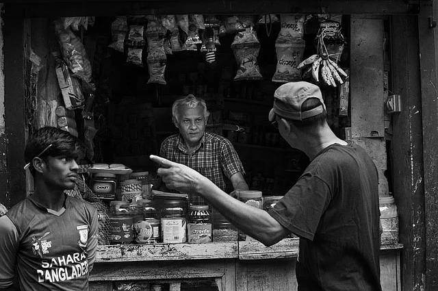 Mr. Harun Rashid Choudhury, a retired official and a Sylhet resident gets direction from a shopkeeper to find Shukla’s house. (Photo: Smita Sharma)