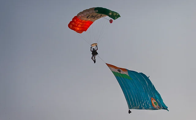 A member of an Indian Air Force (IAF) Akash Ganga skydiving team dives with an IAF flag during the Air Force Day parade at Hindon Air Force base near New Delhi. (Photo: AP)