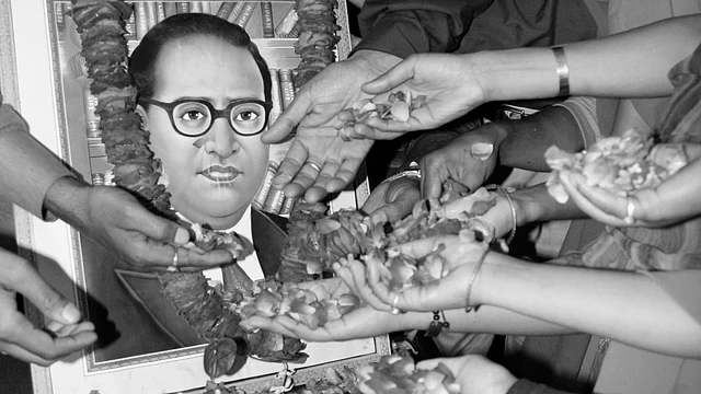 People scatter rose petals in front of a portrait of Dr BR Ambedkar, the author of the Indian Constitution. (Photo: Reuters)