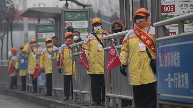 Traffic assisting coordinators wearing masks at a bus station amid heavy smog after Beijing issued its first ever “red alert” for air pollution, December 9, 2015. (Photo: Reuters)