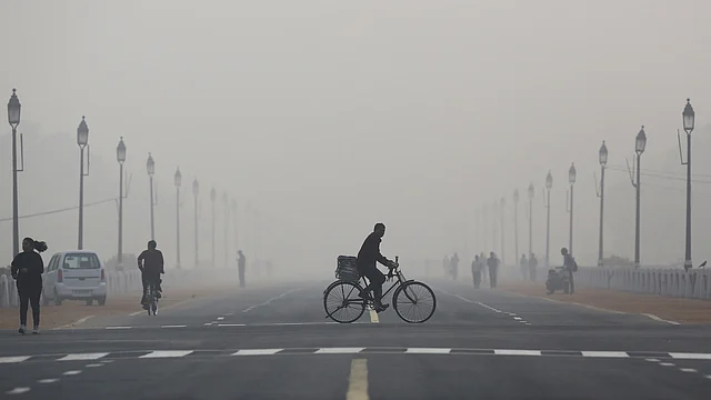 A newspaper vendor rides his bicycle on a smoggy morning in New Delhi, December 1, 2015. (Photo: Reuters)