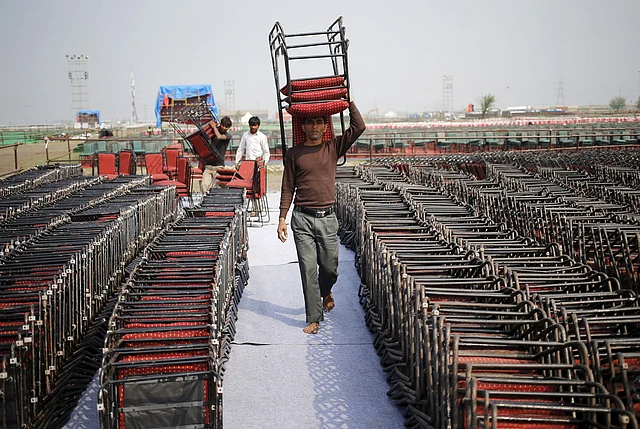 A worker carries chairs at the venue of the World Culture Festival on the banks of the Yamuna. (Photo: Reuters/Anindito Mukherjee)