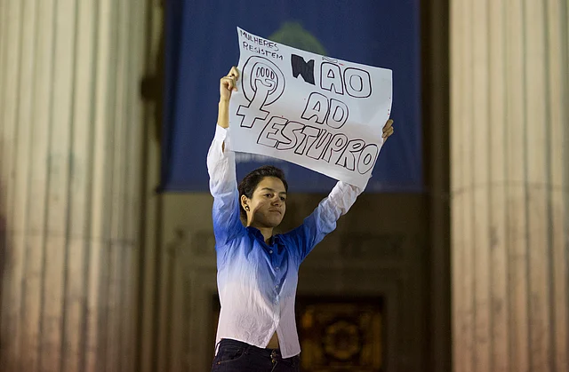A woman holds up a sign that reads in Portuguese “Not to rape” during a protest on Friday. (Photo: AP)