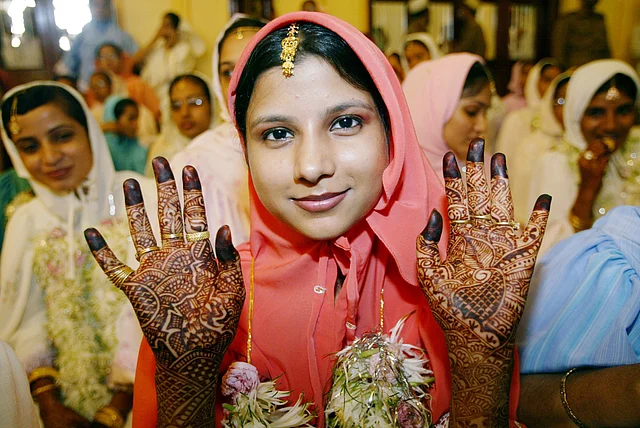 A young Muslim bride belonging to the Dawoodi Bohra community displays her henna-painted palms while waiting for proceedings during a mass wedding in Mumbai. (Photo: Reuters)