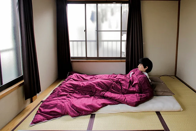 Minimalist Katsuya Toyoda demonstrates how he sleeps in his room in Tokyo. (Photo: Reuters) 